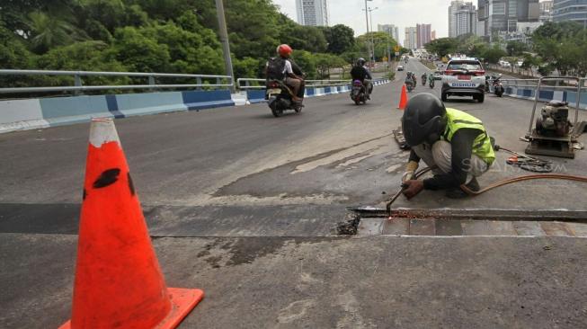 Petugas melakukan perbaikan Jembatan layangnyang renggang di Jalan Layang, Jalan Industri Raya, Kemayoran, Jakarta Pusat, Minggu (6/1). [Suara.com/Muhaimin A Untung] 