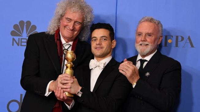 Rami Malek meraih penghargaan Aktor Terbaik di ajang Golden Globe Awards 2019 untuk film Bohemian Rhapsody. Rami berpsoe bersama dua personel Queen:  Roger Taylor (kanan) and Brian May (kiri). (Mark RALSTON / AFP )