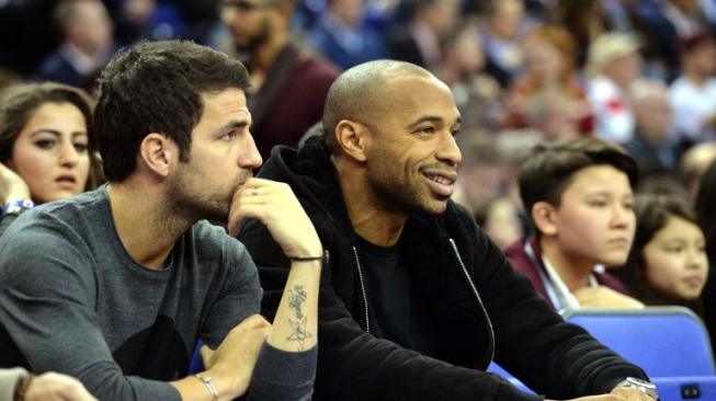 Cesc Fabregas (kiri) menyaksikan pertandingan basket di Amerika Serikat bersama Thierry Henry pada 15 Januari 2015 [AFP]