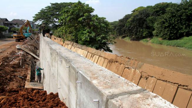 Perbaikan tanggul sungai dan jalan yang amblas di perumahan Kawasan Kemang Pratama, Bekasi, Jawa Barat, Selasa (8/1). [Suara.com/Fakhri Hermansyah]