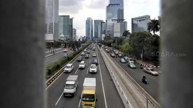 Sejumlah kendaraan melaju di Jalan Gatot Subroto, Jakarta, Jumat (11/1). [Suara.com/Muhaimin A Untung]