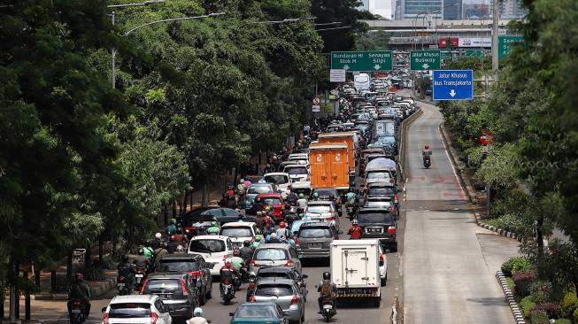 Sejumlah kendaraan melaju di Jalan Gatot Subroto, Jakarta, Jumat (11/1). [Suara.com/Muhaimin A Untung]