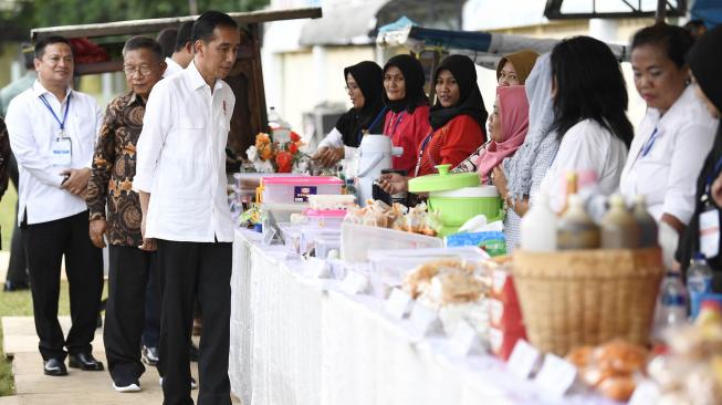 Presiden Joko Widodo meninjau hasil karya Program Mekaar binaan PNM di Lapangan Sepak Bola Gongseng, Jakarta Timur, Kamis (10/1). [ANTARA FOTO/Puspa Perwitasari]