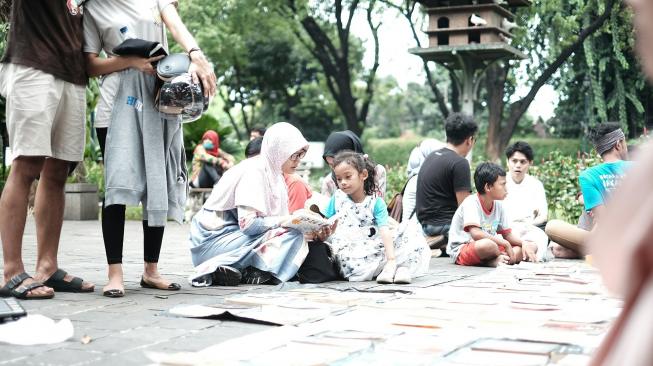 Aktivitas membaca yang dilakukan Komunitas Pecandu Buku sering juga dilakukan di ruangan terbuka. (Foto: Dok. KPB)