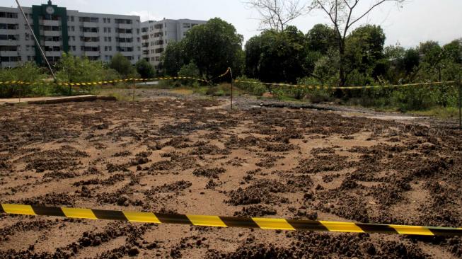 Gundukan tanah yang diduga tercemar limbah B3 di kawasan Marunda, Jakarta Utara, Sabtu (12/1). [Suara.com/Fakhri Hermansyah]
