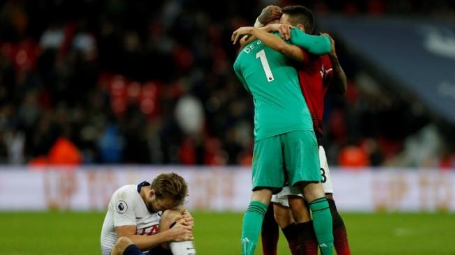 Striker Tottenham Hotspur meringis kesakitan di samping penjaga gawang Manchester United David De Gea yang sedang merayakan kemenangan pada Minggu malam (13/1). MU menang 0-1 atas Spurs di laga itu. [AFP/Ian Kington]