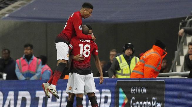 Striker Manchester United Marcus Rashford merayakan golnya dengan rekan setimnya setelah mencetak gol pembuka pertandingan sepakbola Liga Premier Inggris antara Tottenham Hotspur melawan Manchester United di Stadion Wembley, London,Inggris, Minggu (13/1).[Adrian DENNIS / AFP]