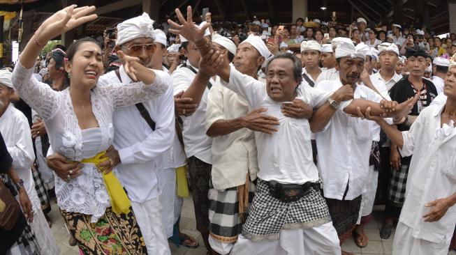 Umat Hindu menari dalam kondisi kesurupan saat Tradisi Ngerebong di Pura Dalem Pengrebongan, Denpasar, Bali, Minggu (13/1). [ANTARA FOTO/Fikri Yusuf]