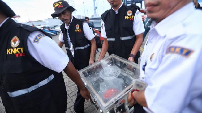 Petugas KNKT membawa Black Box Lion Air JT610 berisi Cockpit Voice Recorder (CVR) pesawat Lion Air bernomor registrasi PK-LQP dengan nomor penerbangan JT 610 yang telah ditemukan oleh Dinas Penyelamatan Bawah Air (Dislambair) Koarmada I di KRI Spica-934 , perairan Tanjung Karawang saat konferensi pers di JICT, pelabuhan Tanjung Priok, Jakarta, Senin (14/1). [Suara.com/Muhaimin A Untung]