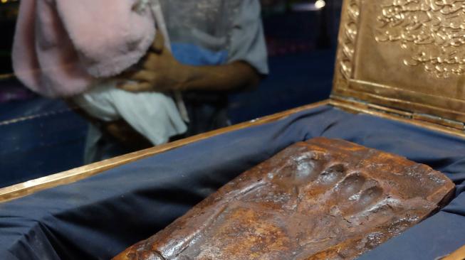 Pengunjung melihat bekas jejak telapak kaki Nabi Muhammad SAW pada Pameran "Artefak Asli Rasulullah dan Para Sahabat" di Medan, Sumatera Utara, Selasa (15/1).  [ANTARA FOTO/Irsan Mulyad]