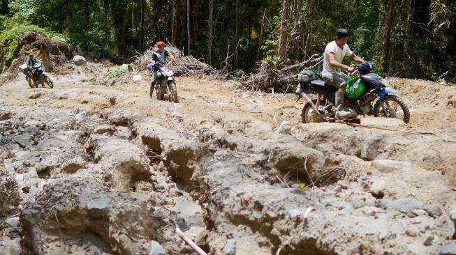 Pengojek 'Rampi' melewati jalan berlubang menuju Kecamatan Rampi, Kabupaten Luwu Utara, Sulawesi Selatan, Minggu (13/01). [ANTARA FOTO/Sahrul Manda Tikupadang]