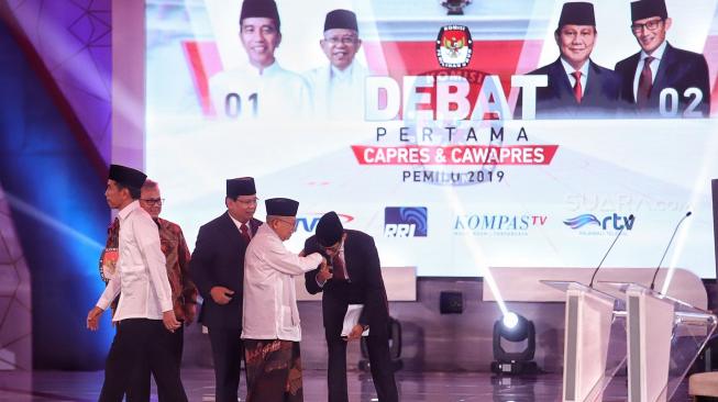 Ketua KPU Arief Budiman bersama pasangan capres-cawapres nomor urut 01 Joko Widodo dan Ma'ruf Amin serta pasangan nomor urut 02 Prabowo Subianto dan Sandiaga Uno bersiap mengikuti debat pertama Pilpres 2019, di Hotel Bidakara, Jakarta, Kamis (17/1). [Suara.com/Muhaimin A Untung]