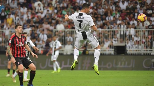 Striker Juventus, Cristiano Ronaldo, mencetak gol dengan sundulan ke gawang AC Milan di laga final Supercoppa Italia, Kamis dini hari (17/1). [AFP/Giuseppe Cacae]