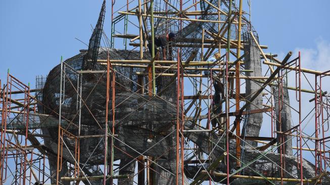 Pekerja menyelesaikan pembangunan patung Suro dan Boyo di Taman Suroboyo, Kenjeran, Surabaya, Jawa Timur, Jumat (18/1).   [ANTARA FOTO/Zabur Karuru]