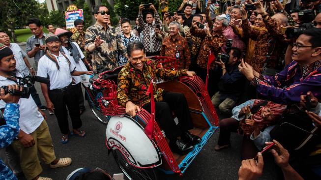 Menteri Energi dan Sumber Daya Mineral (ESDM) Ignasius Jonan (kiri) bersama Rektor Universitas Gadjah Mada (UGM) Panut Mulyono (kanan depan) mencoba becak listrik saat diluncurkan di Balairung UGM, Sleman, DI Yogyakarta, Jumat (18/1). [ANTARA FOTO/Andreas Fitri Atmoko]