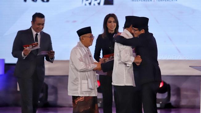 Pasangan capres-cawapres nomor urut 01 Joko Widodo dan Ma'ruf Amin serta pasangan nomor urut 02 Prabowo Subianto dan Sandiaga Uno berpelukan dan bersalaman usai mengikuti debat pertama Pilpres 2019, di Hotel Bidakara, Jakarta, Kamis (17/1). [Suara.com/Muhaimin A Untung]