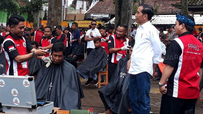 Presiden Joko Widodo saat melihat potong rambut massal di area wisata Situ Bagendit, Garut, Jawa Barat, Sabtu (19/1). [Suara.com/Ummi Hadyah Saleh]