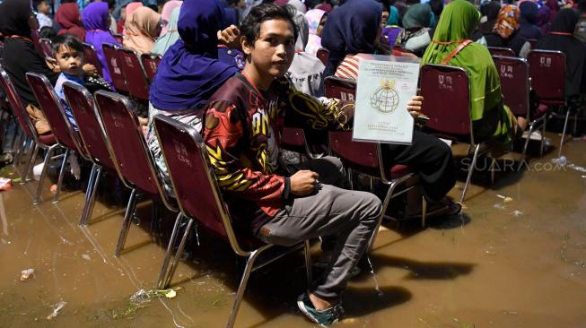 Warga menunjukkan sertifikat miliknya saat acara Penyerahan Sertifikat Tanah untuk Rakyat oleh Presiden Joko Widodo di Banjarsari, Garut, Jawa Barat, Sabtu (19/1). ANTARA FOTO/Puspa Perwitasari