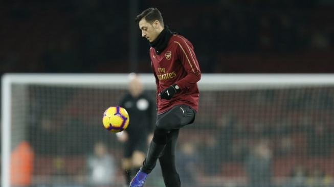 Pemain Arsenal Mesut Ozil melakukan pemanasan jelang pertandingan kontra Chelsea di Emirates Stadium, Minggu (20/1/2019) [AFP]