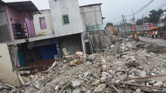 Petugas Dinas Bina Marga DKI Jakarta menggunakan alat berat saat membongkar rumah yang telah dibebaskan lahannya di jalur sejajar rel kawasan Rawajati, Jakarta Selatan, Senin (21/1/2019).  [ANTARA FOTO/Indrianto Eko Suwarso]