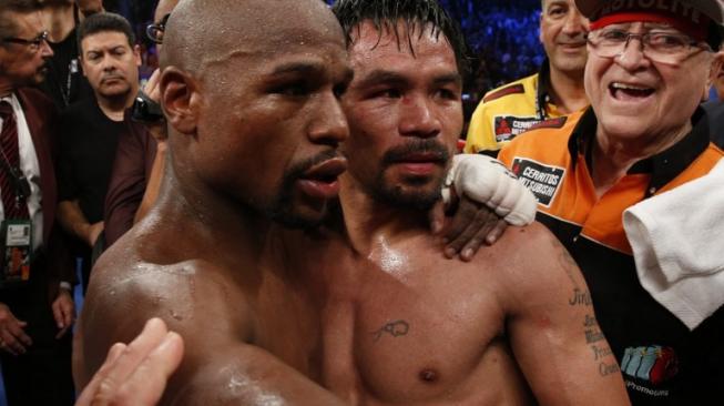 Manny Pacquiao (ketiga dari kanan) dan Floyd Mayweather Jr. berpelukan usai keduanya bertarung di ring tinju pada 2 Mei 2015 di MGM Grand Garden Arena, Las Vegas, Amerika Serikat. [AFP/John Gurzinski]