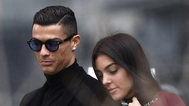 Pemain Juventus Cristiano Ronaldo bersama kekasihnya Georgina Rodriguez meninggalkan gedung pengadilan di Madrid, Spanyol, Selasa (22/1/2019) [AFP]