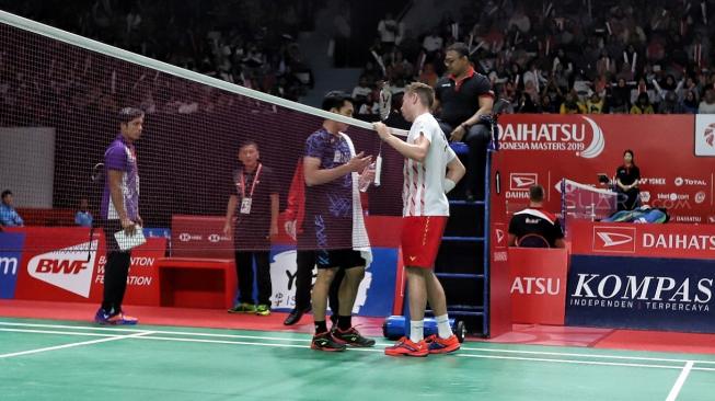 Pebulutangkis tunggal putra Indonesia Jonatan Christie berbincang dengan pebulutangkis tunggal putra Denmark Rasmus Gemke dalam babak pertama Indonesia Masters 2019 di Istora Senayan, Jakarta, Rabu (23/1). [Suara.com/Muhaimin A Untung] 