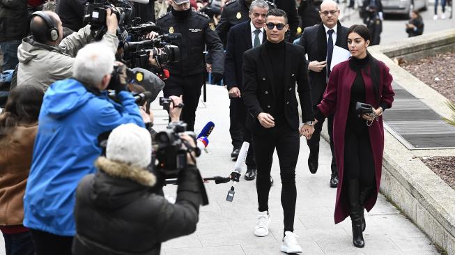 Pemain Juventus Cristiano Ronaldo bersama kekasihnya Georgina Rodriguez saat menghadiri sidang dugaan penggelapan pajak di Kota Madrid, Spanyol, Selasa (22/1). [PIERRE-PHILIPPE MARCOU / AFP]