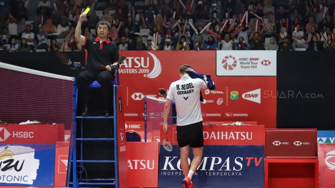 Ganda putra Indonesia Kevin Sanjaya Sukamuljo dan Marcus Fernaldi Gideon berusaha mengembalikan kok searah ganda Jerman Mark Lamfus dan Marvin Emil Seidel saat pertandingan babak pertama Daihatsu Indonesia Masters 2019 di Istora Senayan, Jakarta, Rabu (23/1). [Suara.com/Muhaimin A Untung]