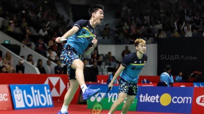 Ganda putra Indonesia Kevin Sanjaya Sukamuljo dan Marcus Fernaldi Gideon berusaha mengembalikan kok searah ganda Jerman Mark Lamfus dan Marvin Emil Seidel saat pertandingan babak pertama Daihatsu Indonesia Masters 2019 di Istora Senayan, Jakarta, Rabu (23/1). [Suara.com/Muhaimin A Untung]