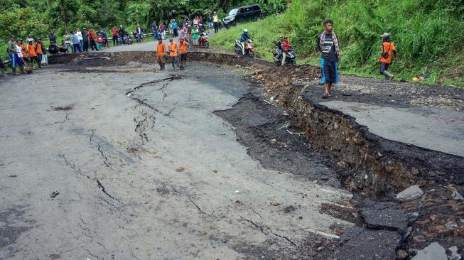 Sejumlah warga melihat jalan yang ambles di Desa Tenogo, Paninggaran, Kabupaten Pekalongan, Jawa Tengah, Rabu (23/1). [ANTARA FOTO/Harviyan Perdana Putra]