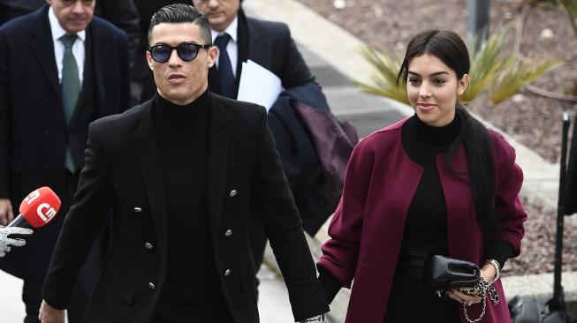 Pemain Juventus Cristiano Ronaldo bersama kekasihnya Georgina Rodriguez saat menghadiri sidang dugaan penggelapan pajak di Kota Madrid, Spanyol, Selasa (22/1). [PIERRE-PHILIPPE MARCOU / AFP]