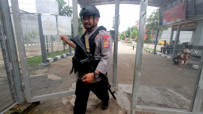 Personel kepolisian berjalan saat berjaga di pintu masuk Lapas Gunung Sindur di Bogor, Jawa Barat , Rabu (23/1). [ANTARA FOTO/Yulius Satria Wijaya]