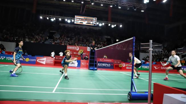 Ganda putra Indonesia Kevin Sanjaya Sukamuljo dan Marcus Fernaldi Gideon berusaha mengembalikan kok searah ganda Jerman Mark Lamfus dan Marvin Emil Seidel saat pertandingan babak pertama Daihatsu Indonesia Masters 2019 di Istora Senayan, Jakarta, Rabu (23/1). [Suara.com/Muhaimin A Untung]