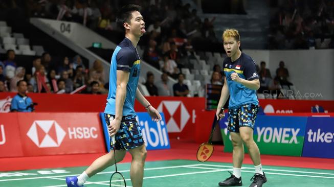 Ganda putra Indonesia Kevin Sanjaya Sukamuljo dan Marcus Fernaldi Gideon berusaha mengembalikan kok searah ganda Jerman Mark Lamfus dan Marvin Emil Seidel saat pertandingan babak pertama Daihatsu Indonesia Masters 2019 di Istora Senayan, Jakarta, Rabu (23/1). [Suara.com/Muhaimin A Untung]