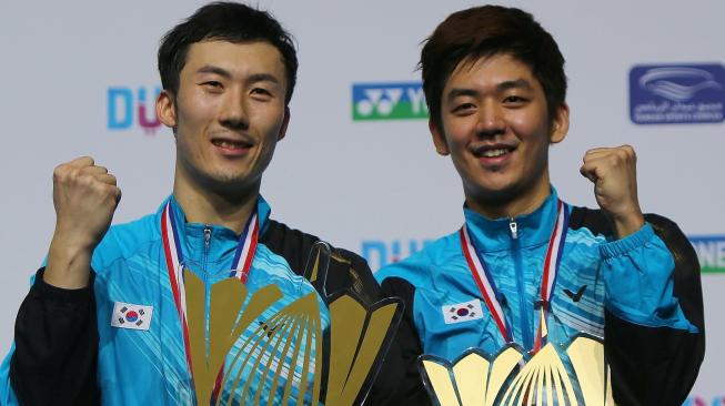 Pasangan ganda putra Korea Selatan, Lee Yong Dae (kanan) dan Yoo Yeon-seong, merayakan keberhasilan mereka menjuarai BWF World Superseries Finals 2014. [AFP/Marwan Naamani]