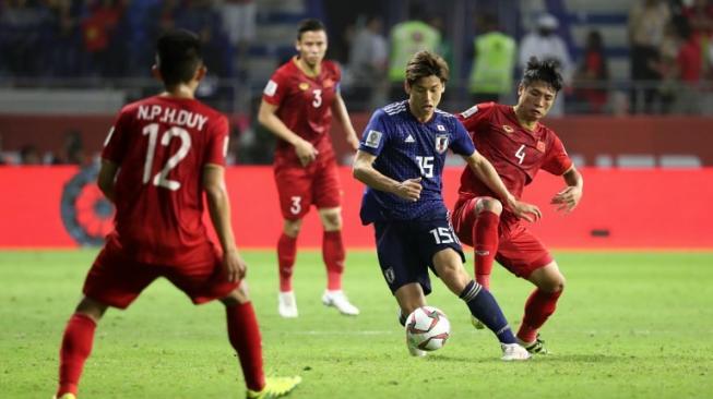 Pemain Jepang Yuya Osaka melewati kejaran pemain Vietnam dalam pertandingan perempat final Piala Asia 2019, Kamis (24/1/2019) [AFP]