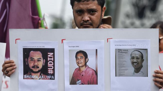 Sejumlah jurnalis membentangkan spanduk dan poster saat menggelar aksi tolak remisi pembunuh jurnalis di Taman Aspirasi, Jakarta, Jumat (25/1). [Suara.com/Muhaimin A Untung]