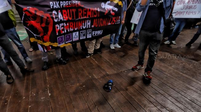 Sejumlah jurnalis membentangkan spanduk dan poster saat menggelar aksi tolak remisi pembunuh jurnalis di Taman Aspirasi, Jakarta, Jumat (25/1). [Suara.com/Muhaimin A Untung]