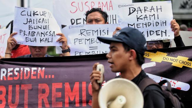 Sejumlah jurnalis membentangkan spanduk dan poster saat menggelar aksi tolak remisi pembunuh jurnalis di Taman Aspirasi, Jakarta, Jumat (25/1). [Suara.com/Muhaimin A Untung]