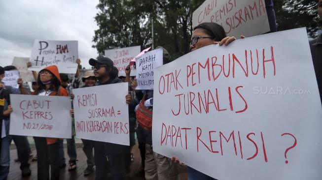 Sejumlah jurnalis membentangkan spanduk dan poster saat menggelar aksi tolak remisi pembunuh jurnalis di Taman Aspirasi, Jakarta, Jumat (25/1). [Suara.com/Muhaimin A Untung]