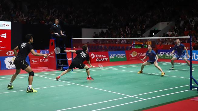 Pebulu tangkis ganda campuran Indonesia Liliyana Natsir dan Tontowi Ahmad saat berusaha mengembalikan kok ke ganda campuran Cina Zheng Siwei dan Huang Yaqiong pada pertandingan final Daihatsu Indonesia Masters 2019 di Istora Senayan, Jakarta, Minggu (27/1). [Suara.com/Muhaimin A Untung]