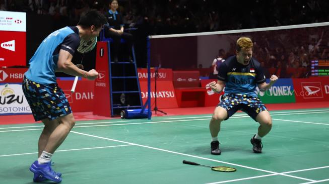 Ganda putra Indonesia Marcus Fernaldi Gideon (kanan) dan Kevin Sanjaya Sukomuljo meluapkan kegembiraan seusai mengalahkan ganda putra Indonesia Mohammad Ahsan dan Hendra Setiawan pada pertandingan final Daihatsu Indonesia Masters 2019 di Istora Senayan, Jakarta, Minggu (27/1). [Suara.com/Muhaimin A Untung]