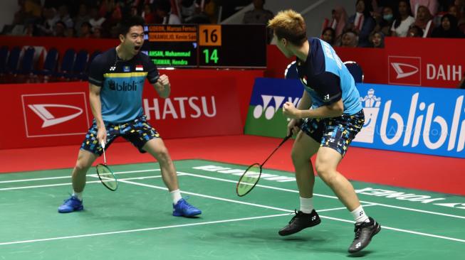 Ganda putra Indonesia Marcus Fernaldi Gideon (kanan) dan Kevin Sanjaya Sukomuljo meluapkan kegembiraan seusai mengalahkan ganda putra Indonesia Mohammad Ahsan dan Hendra Setiawan pada pertandingan final Daihatsu Indonesia Masters 2019 di Istora Senayan, Jakarta, Minggu (27/1). [Suara.com/Muhaimin A Untung]