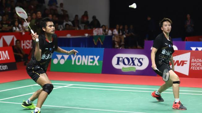 Pebulu tangkis ganda campuran Indonesia Liliyana Natsir dan Tontowi Ahmad saat berusaha mengembalikan kok ke ganda campuran Cina Zheng Siwei dan Huang Yaqiong pada pertandingan final Daihatsu Indonesia Masters 2019 di Istora Senayan, Jakarta, Minggu (27/1). [Suara.com/Muhaimin A Untung]