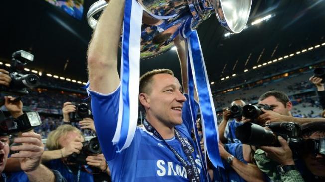 Mantan kapten Chelsea, John Terry saat mengangkat trofi juara Liga Champions musim 2011/2012. [ADRIAN DENNIS / AFP]