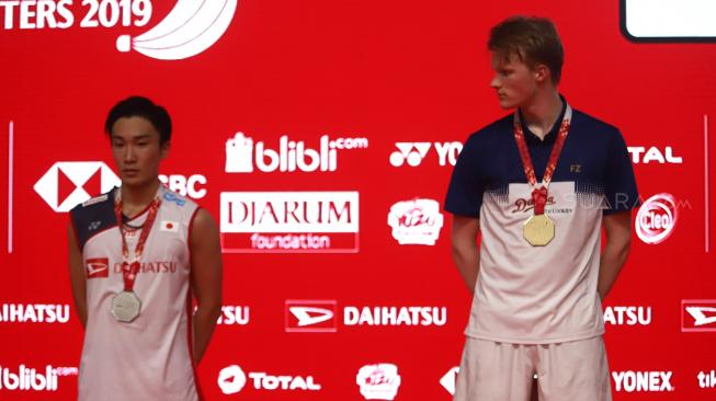 Pebulu tangkis Jepang Kento Momota dan pebulu tangkis Denmark Anders Antonsen saat penerimaan medali dalam final tunggal putra Daihatsu Indonesia Masters 2019 di Istora Senayan, Jakarta, Minggu (27/1). [Suara.com/Muhaimin A Untung]