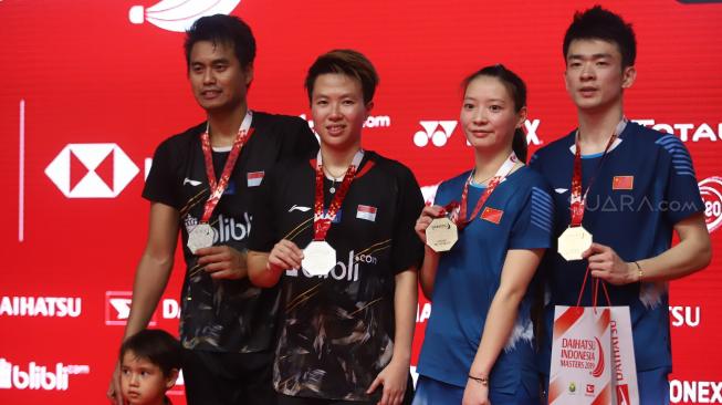 Ganda campuran Indonesia Tontowi Ahmad (kiri) dan Liliyana Natsir (kedua kiri) berpose bersama pasangan Cina Zheng Siwei (kanan) dan Huang Yaqiong (kedua kanan) usai penyerahan medali Daihatsu Indonesia Masters 2019 di Istora Senayan, Jakarta, Minggu (27/1). [Suara.com/Muhaimin A Untung]