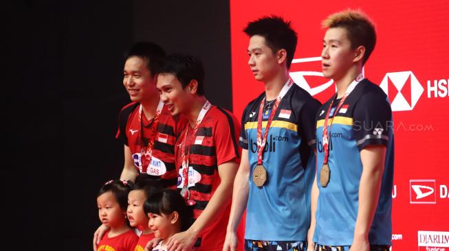 Ganda putra Indonesia Marcus Fernaldi Gideon dan Kevin Sanjaya Sukomuljo menunjukkan medali seusai final ganda putra Indonesia Mohammad Ahsan dan Hendra Setiawan pada pertandingan final Daihatsu Indonesia Masters 2019 di Istora Senayan, Jakarta, Minggu (27/1). [Suara.com/Muhaimin A Untung]