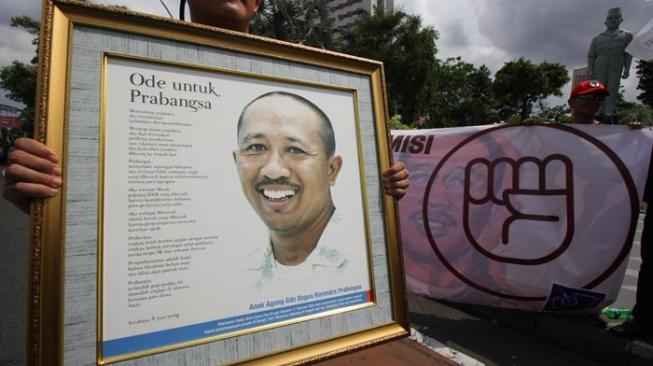 Jurnalis memegang foto jurnalis Radar Bali Anak Agung Bagus Narendra Prabangsa yang menjadi korban pembunuhan pada tahun 2009. [Antara Foto]